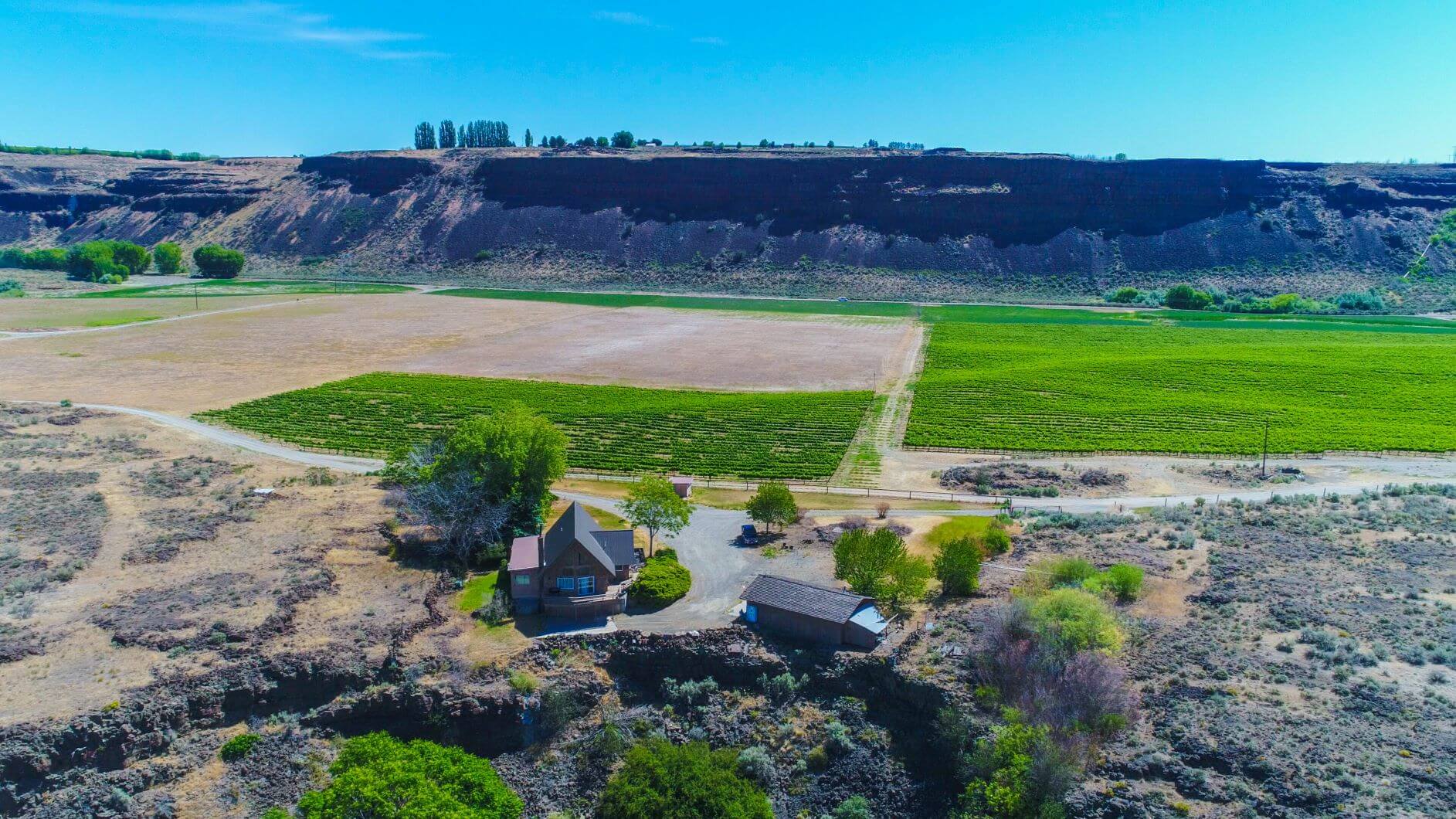 Building surrounded by trees and dry landscape near trail area.